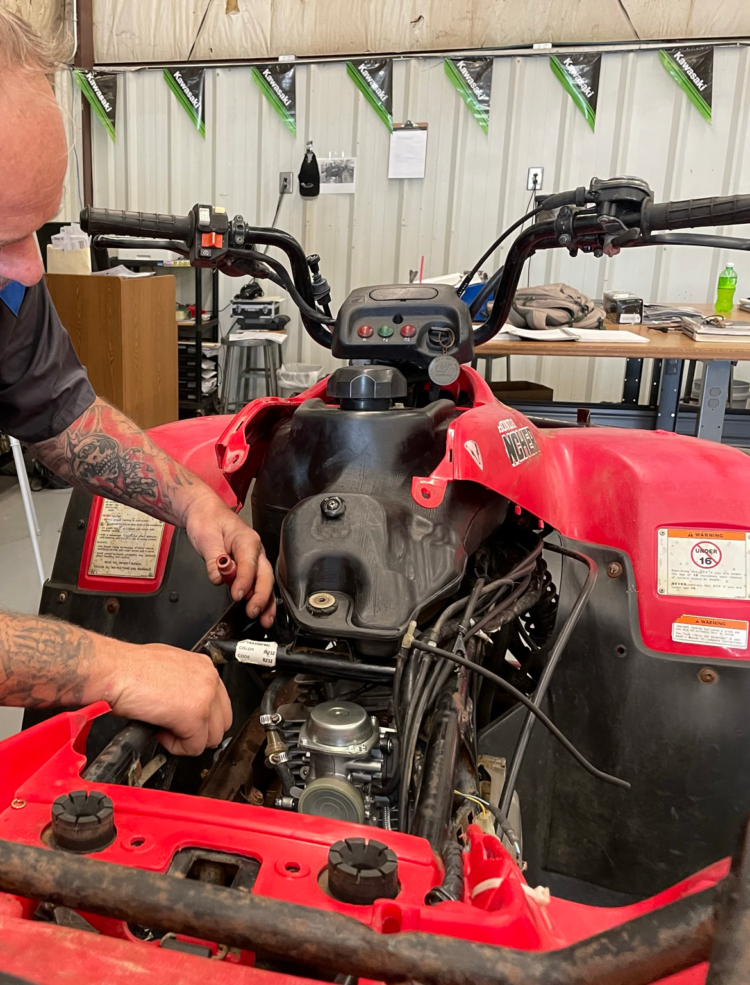 a man working on a red vehicle